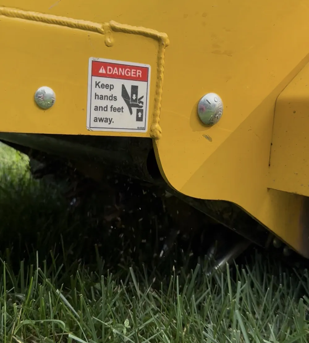 Core aeration machine pulling plugs from a lawn in Bucks County, PA